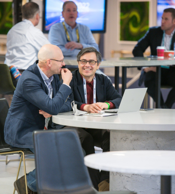 Two men sit at a table at Retail's Big Show networking